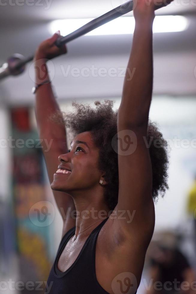 black woman lifting empty bar photo