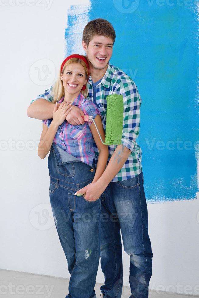 happy couple paint wall at new home photo