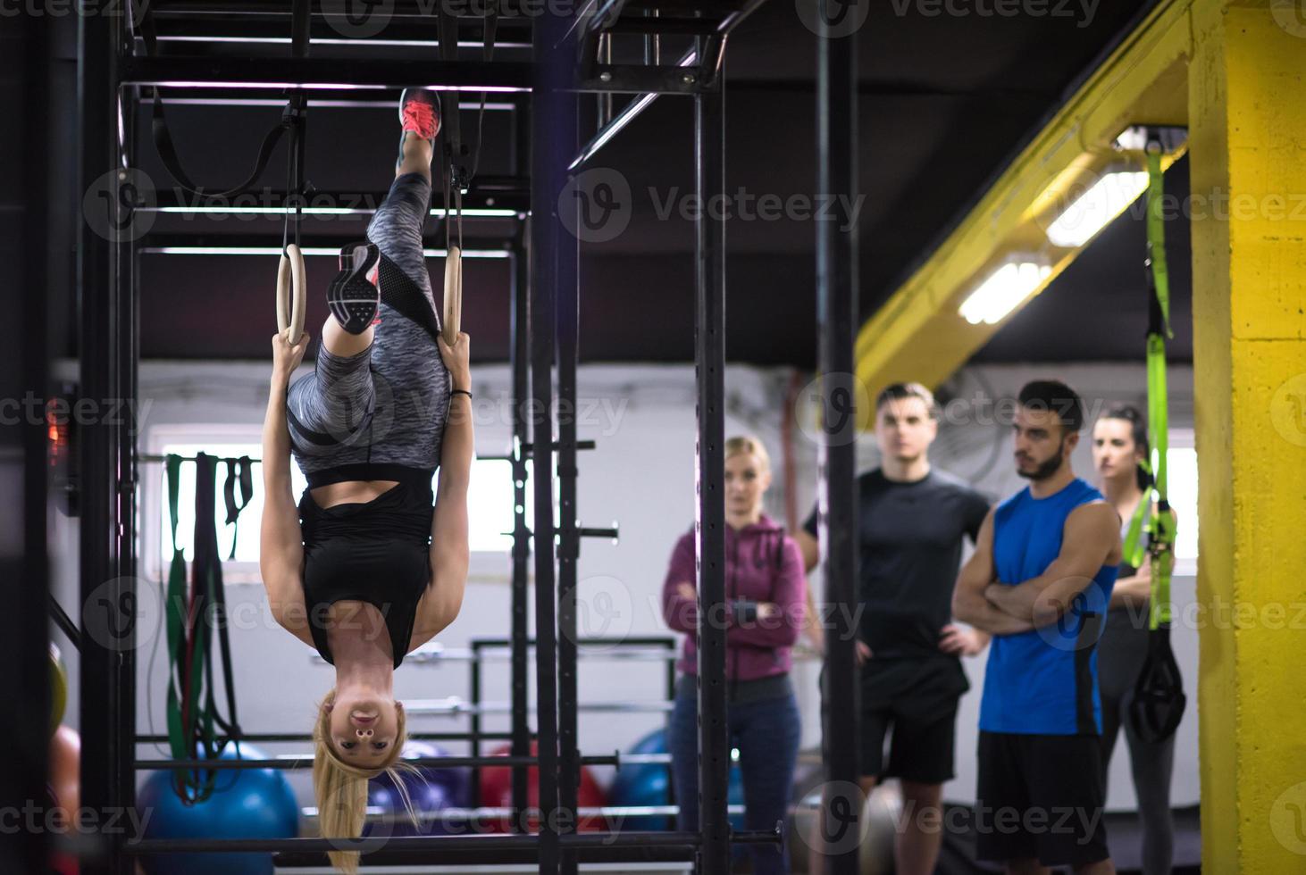 mujer trabajando con entrenador personal en anillos de gimnasia foto