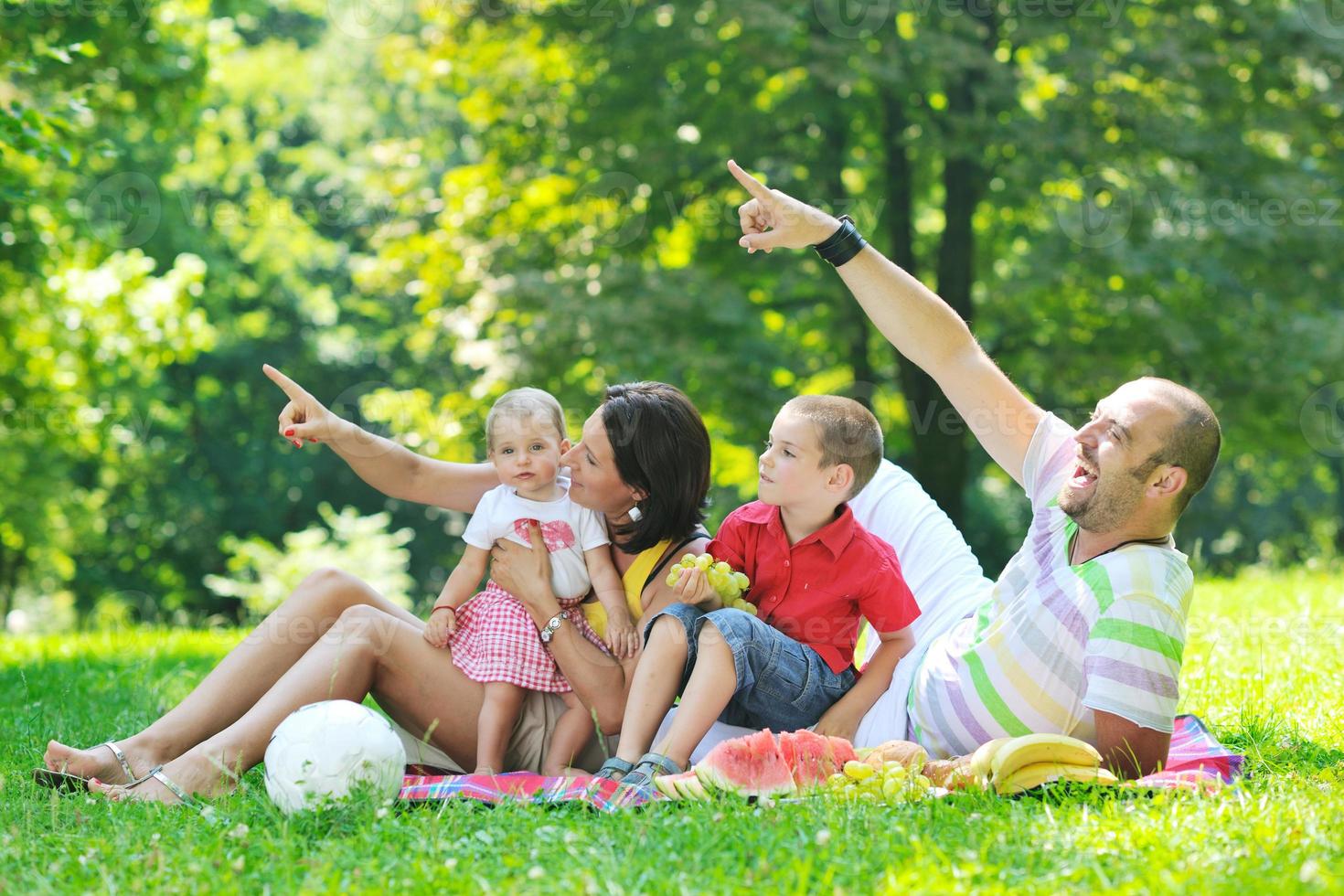 Feliz pareja joven con sus hijos divertirse en el parque foto