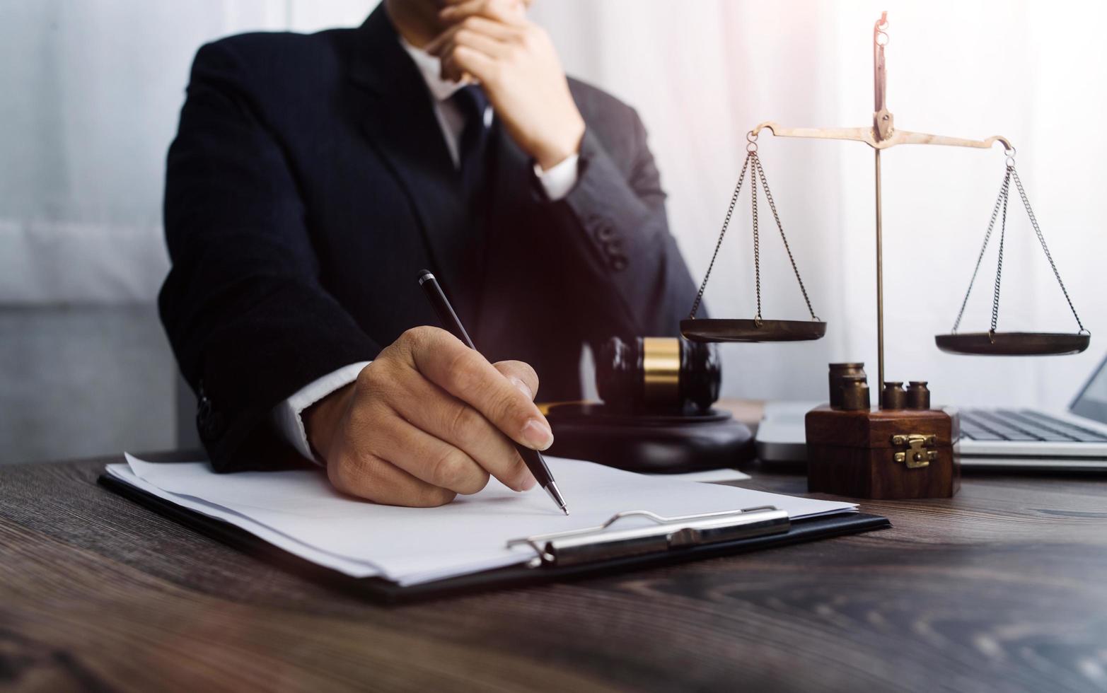 Business and lawyers discussing contract papers with brass scale on desk in office. Law, legal services, advice, justice and law concept picture with film grain effect photo