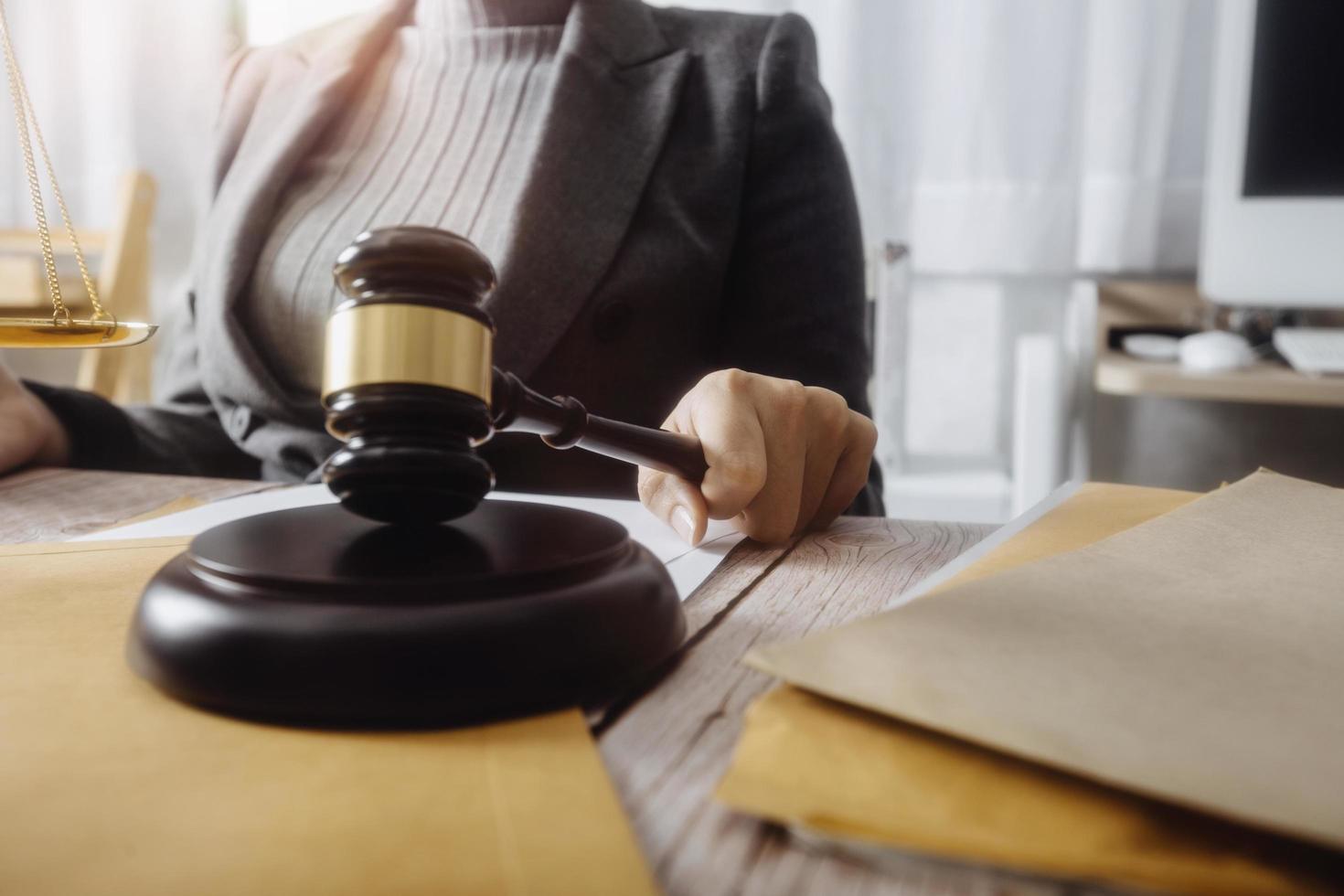 Business and lawyers discussing contract papers with brass scale on desk in office. Law, legal services, advice, justice and law concept picture with film grain effect photo