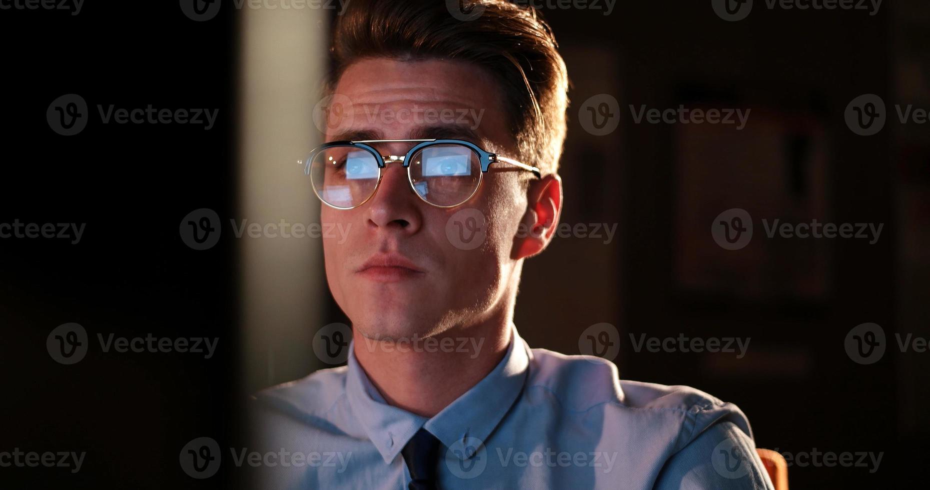 man working on computer in dark office photo