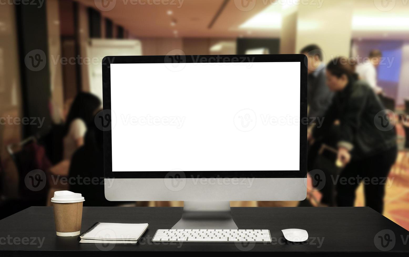 Front view of Computer monitor  cup and computer laptop, smartphone, and tablet on table in meeting room photo