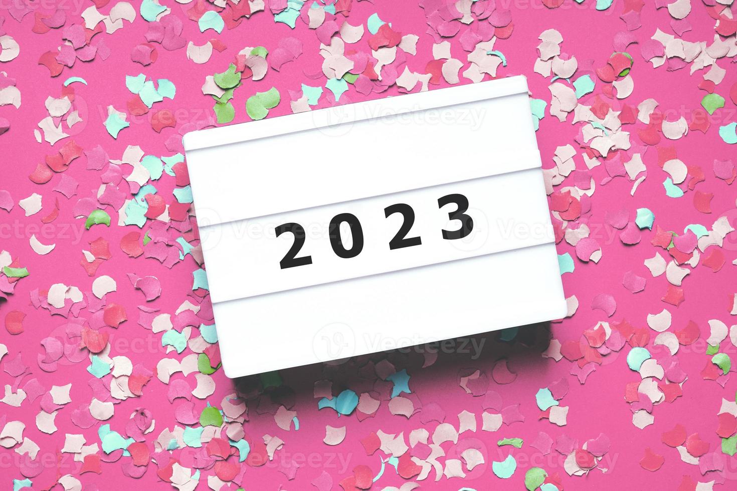 happy new year 2023 party celebration flat lay with confetti in pink photo