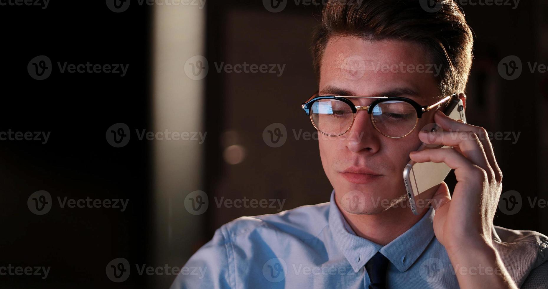 man using mobile phone in dark office photo