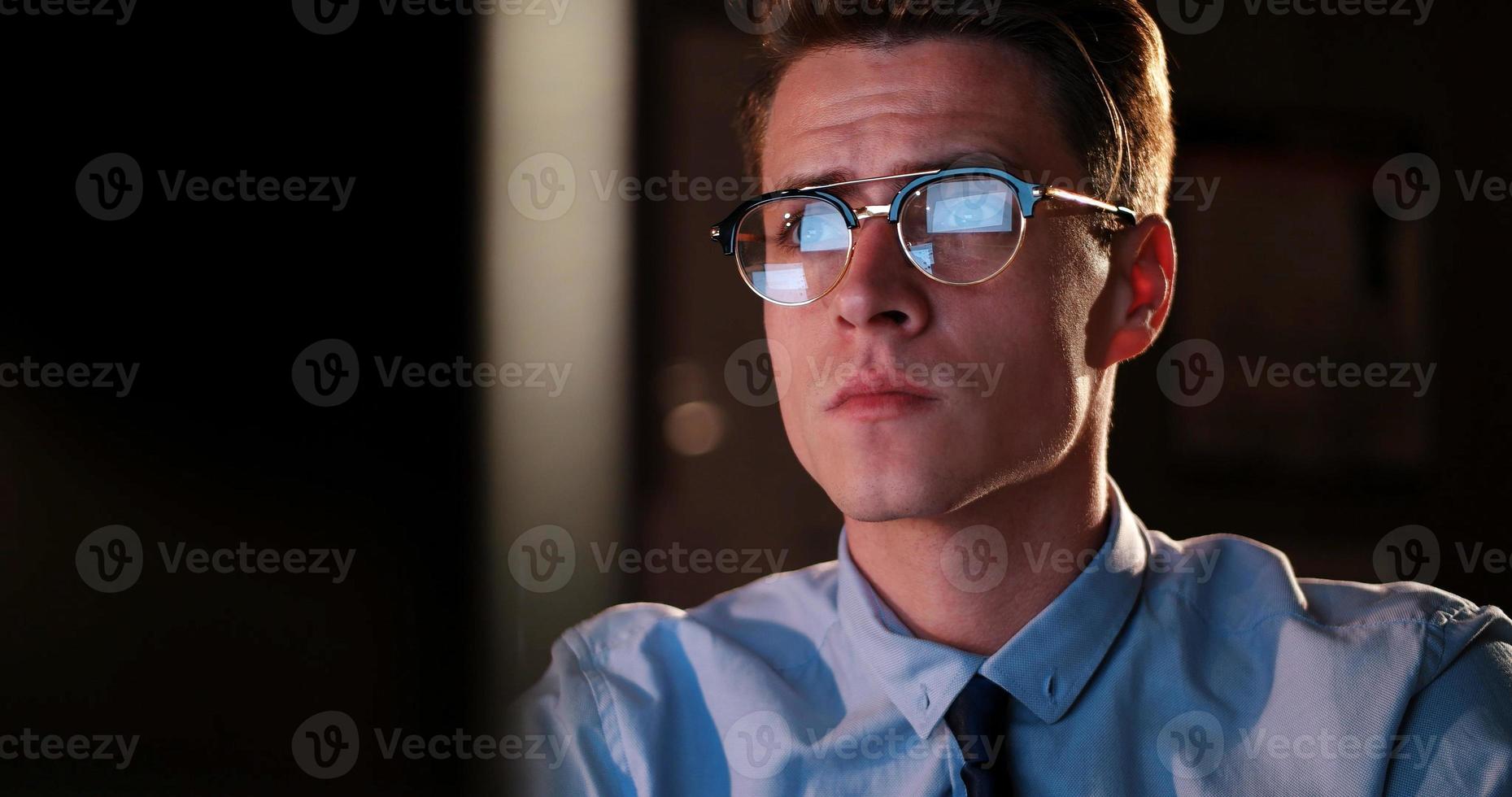 man working on computer in dark office photo