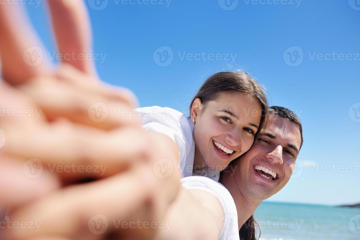 happy young couple have fun on beach photo
