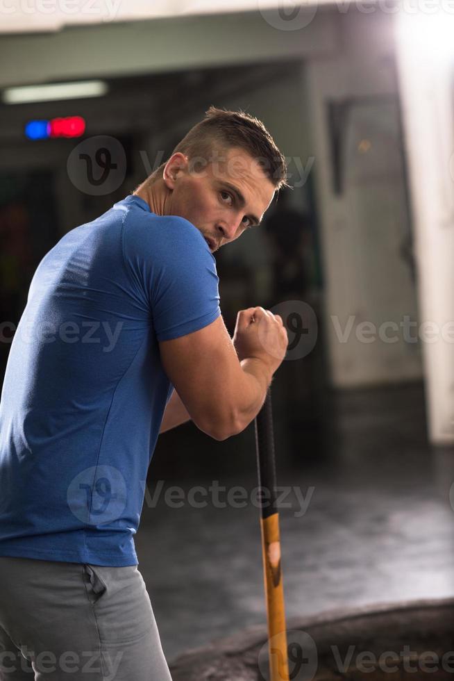 entrenamiento de hombre con martillo y neumático de tractor foto