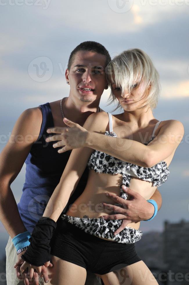 romantic urban couple dancing on top of the bulding photo