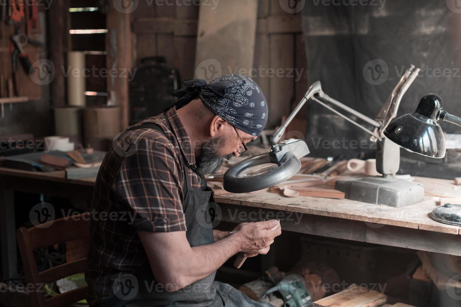 Spoon master in his workshop with wooden products and tools photo