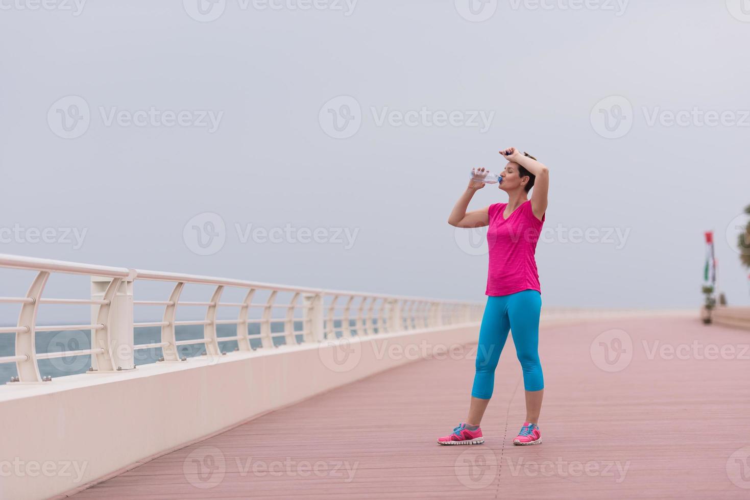 Fitness woman drinking water photo