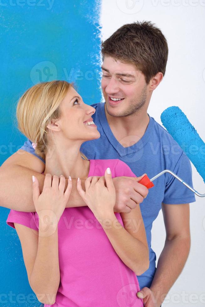happy couple paint wall at new home photo