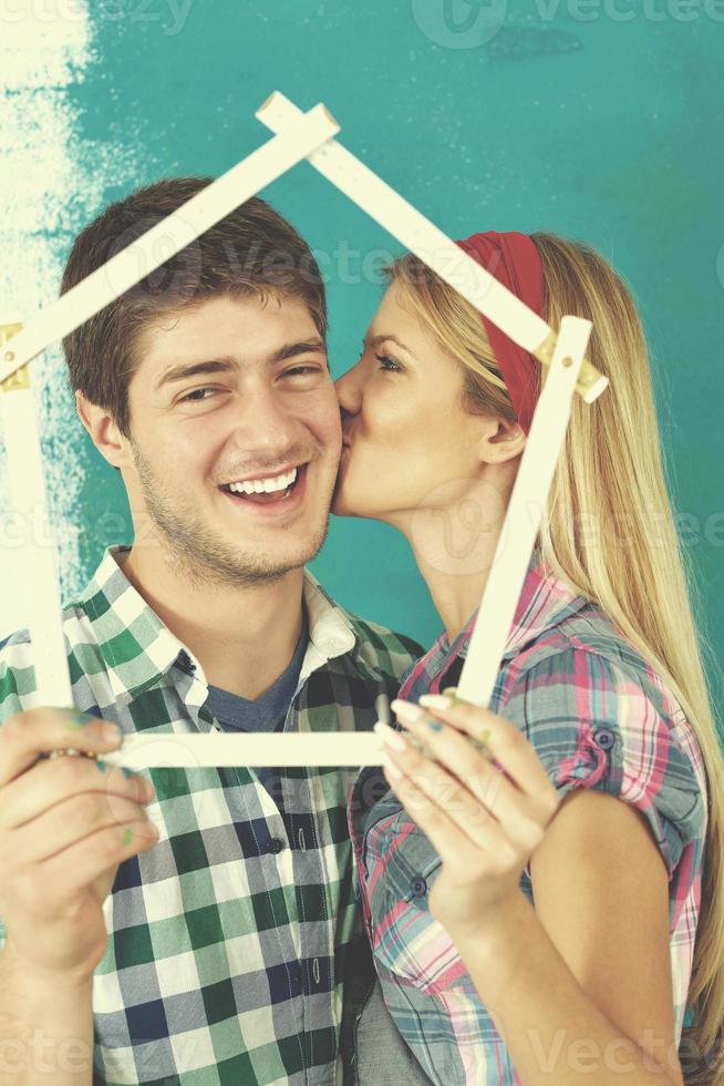 pareja feliz pintando una pared en su nuevo hogar foto