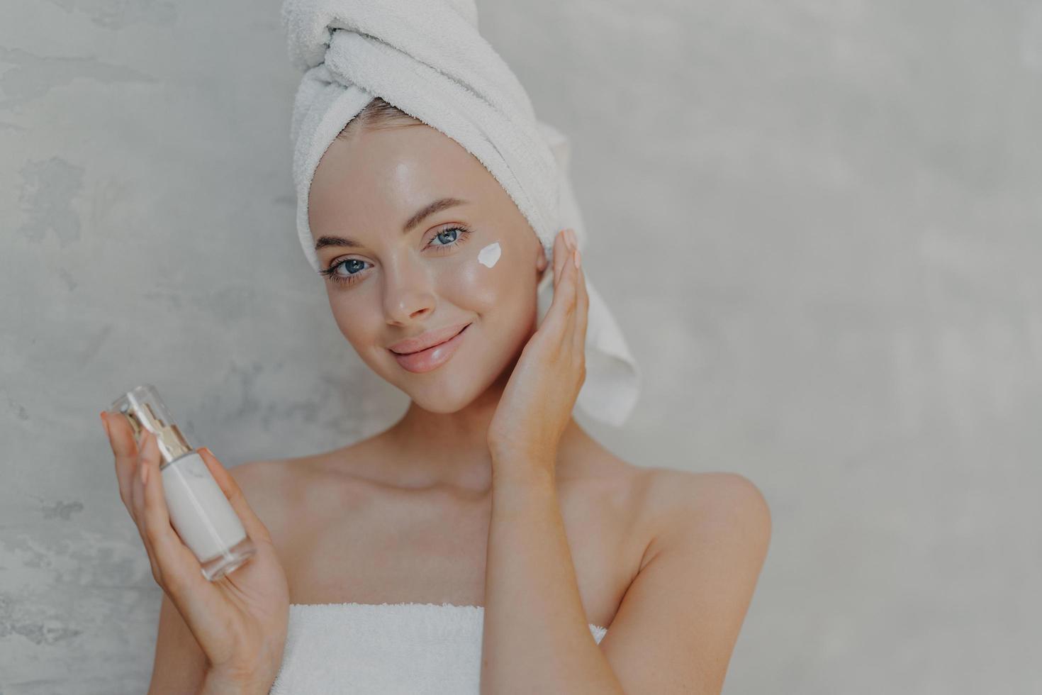 https://static.vecteezy.com/system/resources/previews/011/315/459/non_2x/beautiful-tender-smiling-woman-applies-face-cream-takes-care-of-her-beauty-has-natural-makeup-clean-perfect-skin-wrapped-in-bath-towel-poses-against-grey-background-beauty-treatments-concept-free-photo.JPG