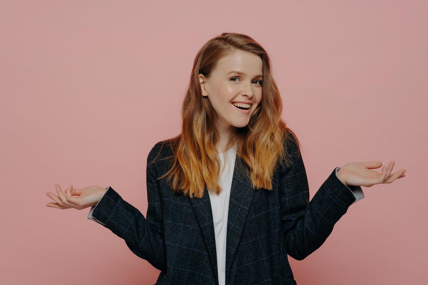 Positive young girl raising hands with open palm gesture photo