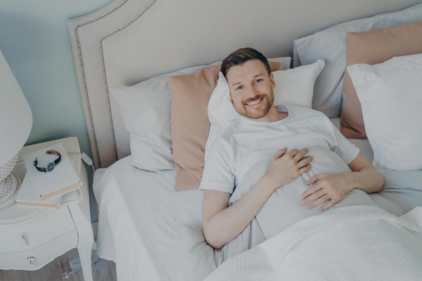 Young well rested man waking up in morning at home photo