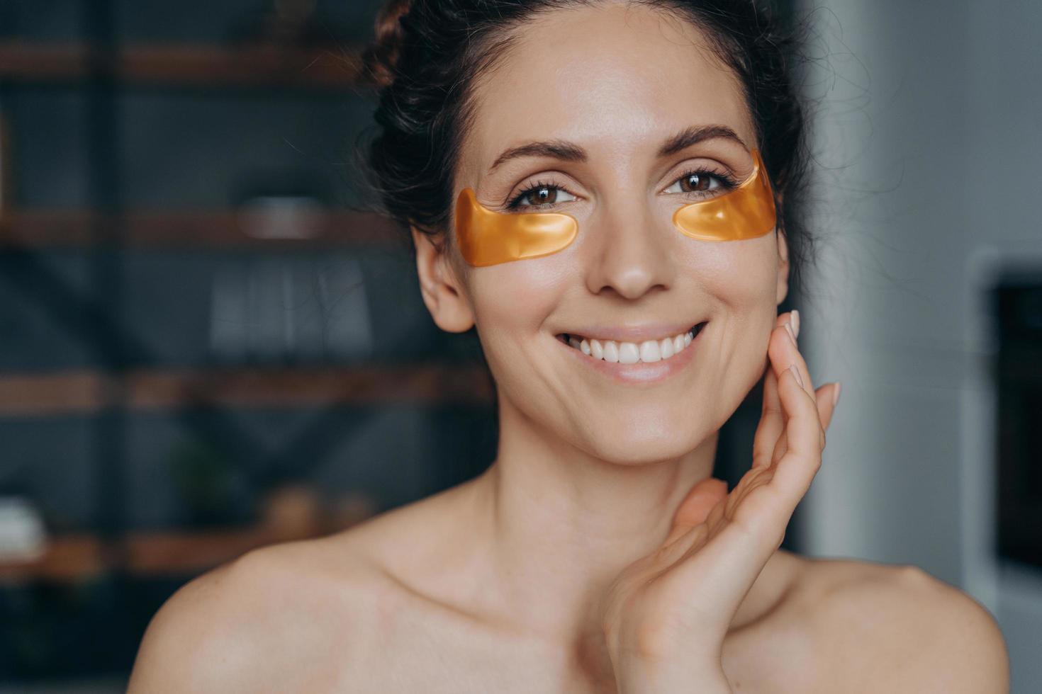 Happy european girl doing spa procedures and touches her face skin. Relaxation and skincare. photo