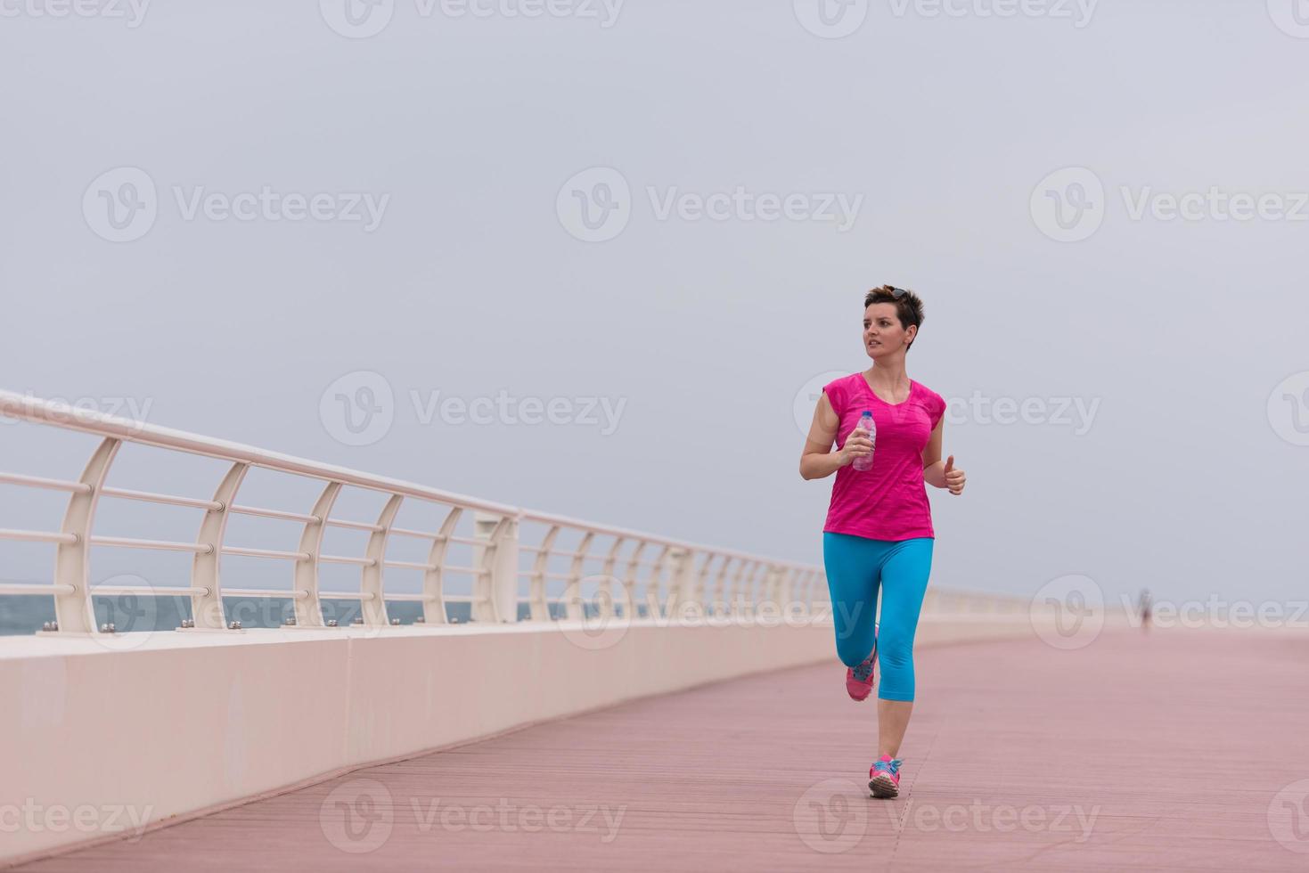 mujer ocupada corriendo en el paseo marítimo foto