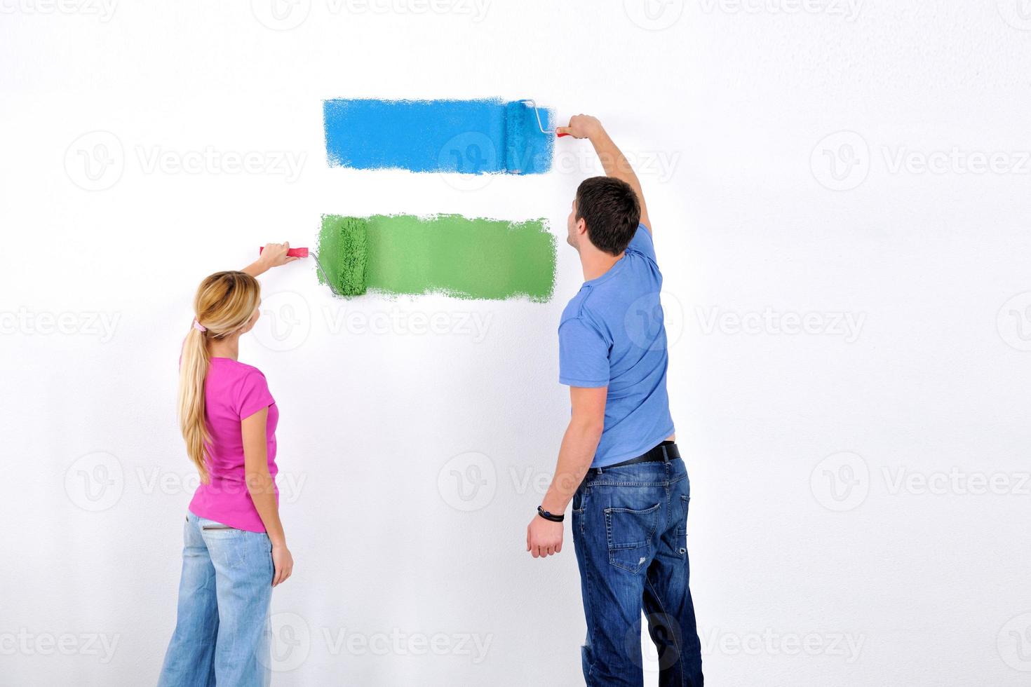 happy couple paint wall at new home photo