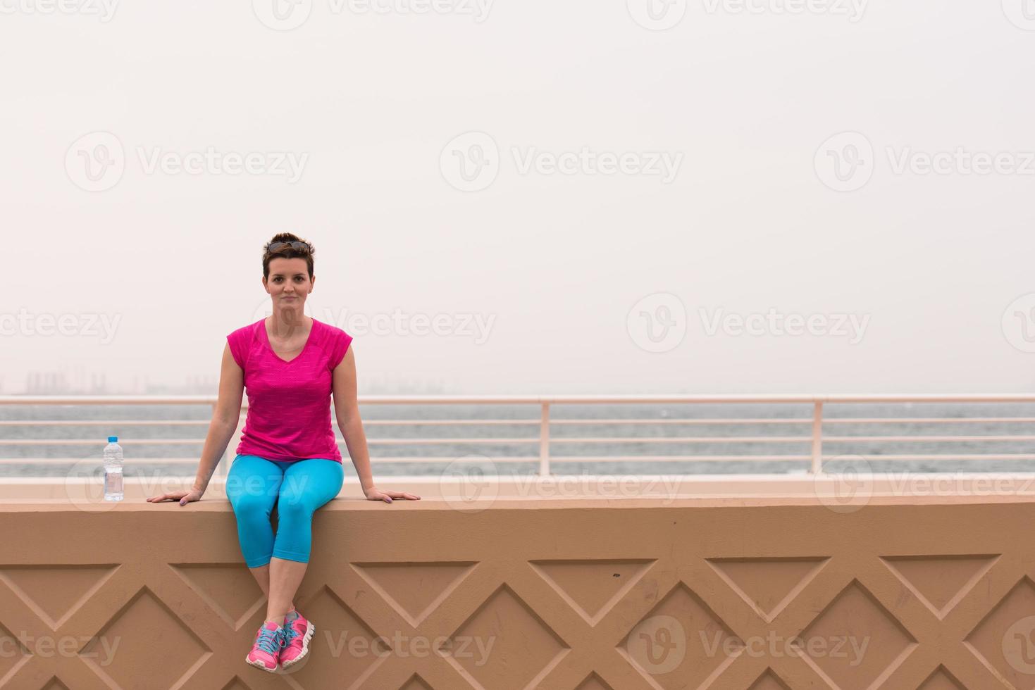 young woman sitting after a successful training run photo