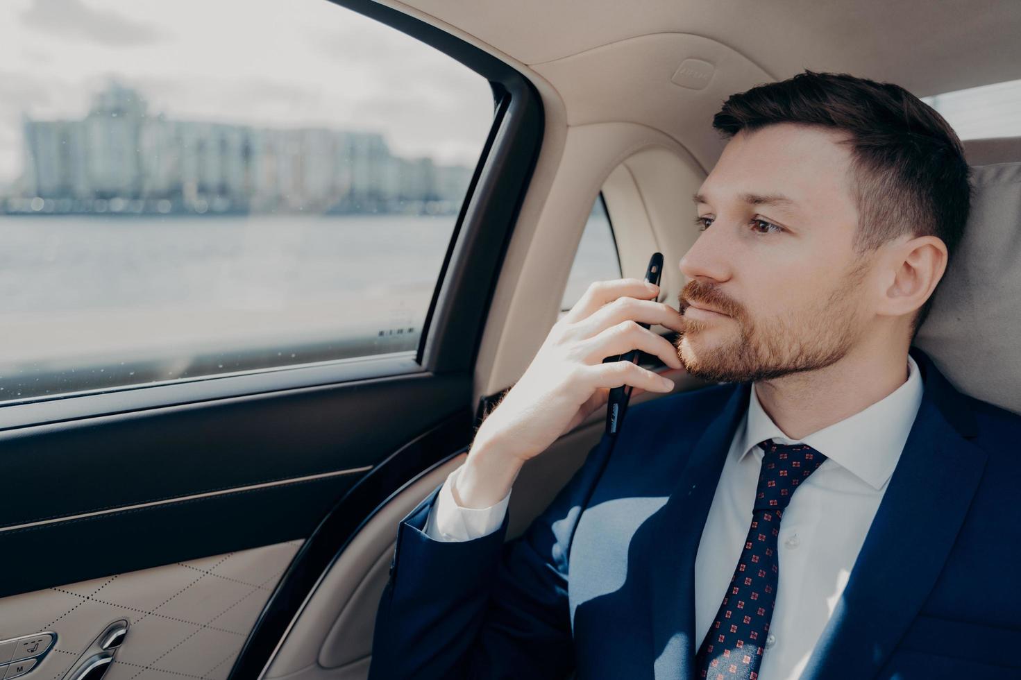 Serious company executive thinking of making serious decision while sitting in car photo