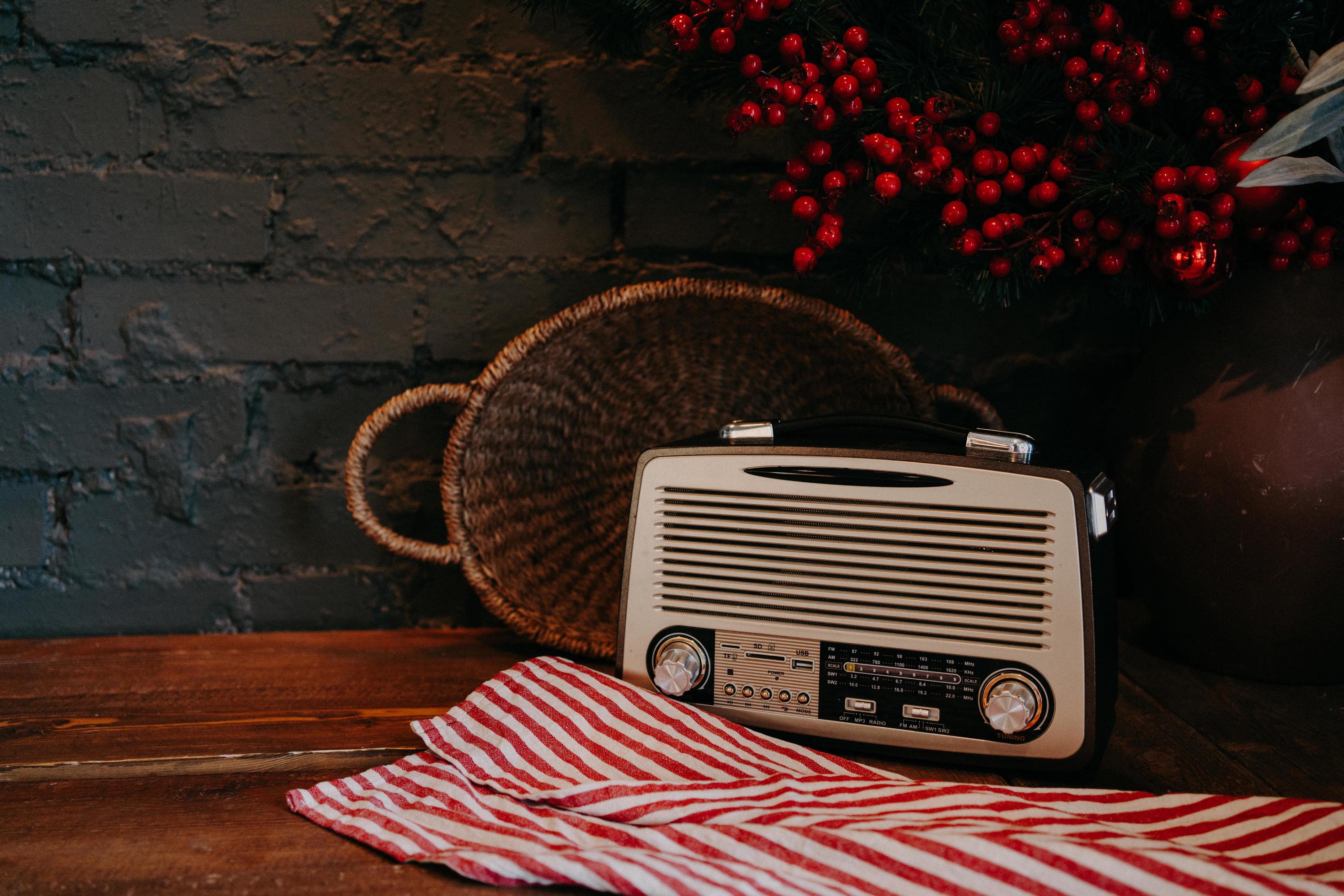 Retro radio on wooden table with wicker basket and floral decor