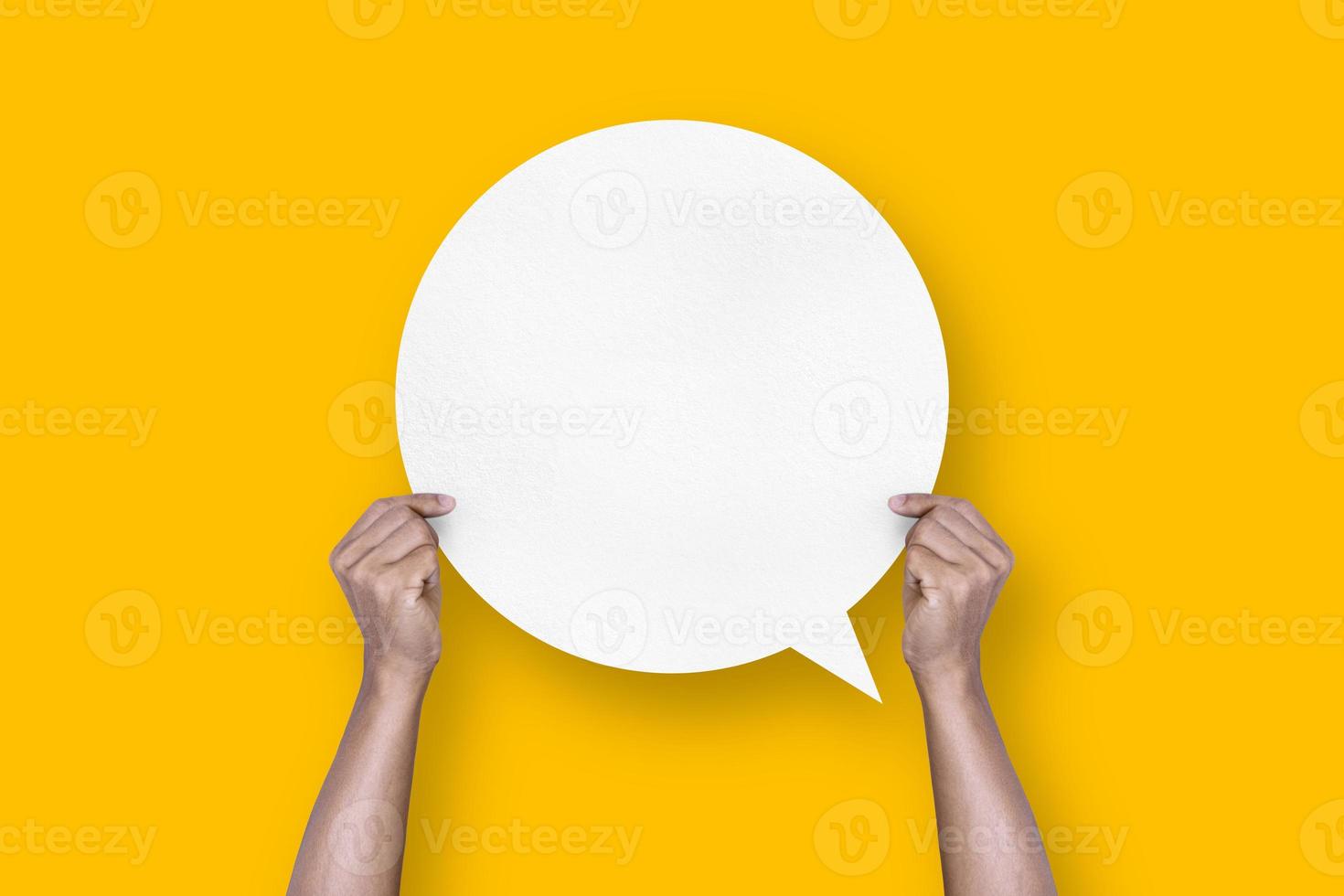 hand holding round white paper balloons speech bubbles isolated on yellow background photo