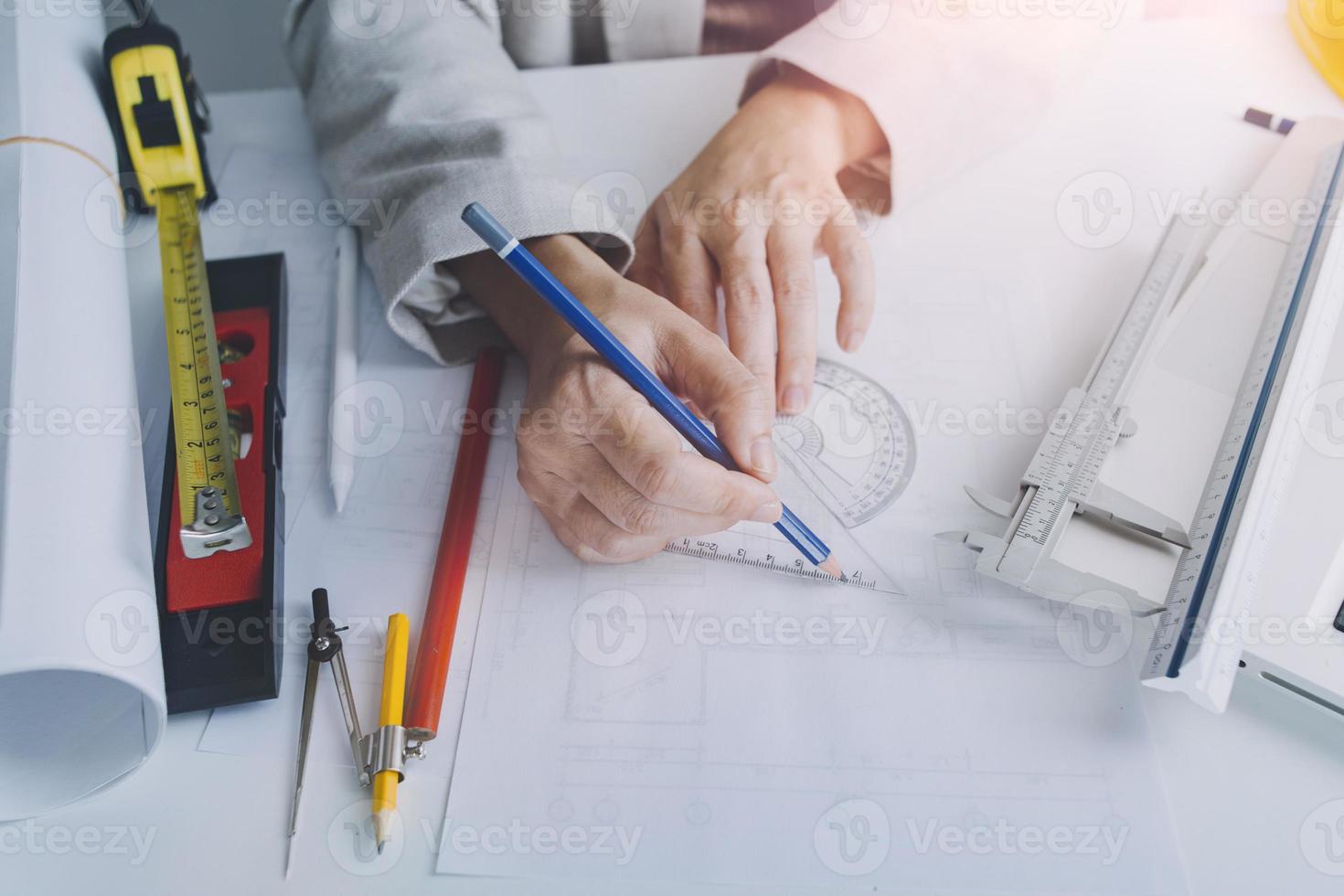 Two colleagues discussing data working and tablet, laptop with on on architectural project at construction site at desk in office photo