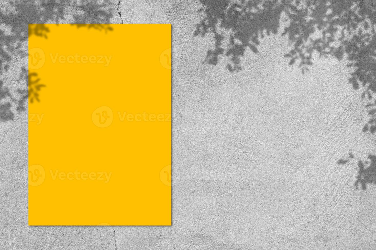 Empty yellow square poster mockup with light shadow on gray concrete wall background. photo
