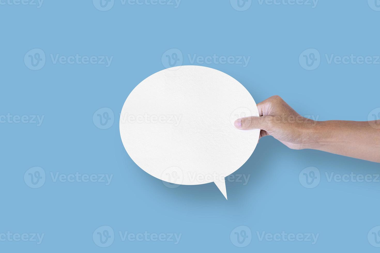 hand holding round white paper balloons speech bubbles isolated on light blue background photo