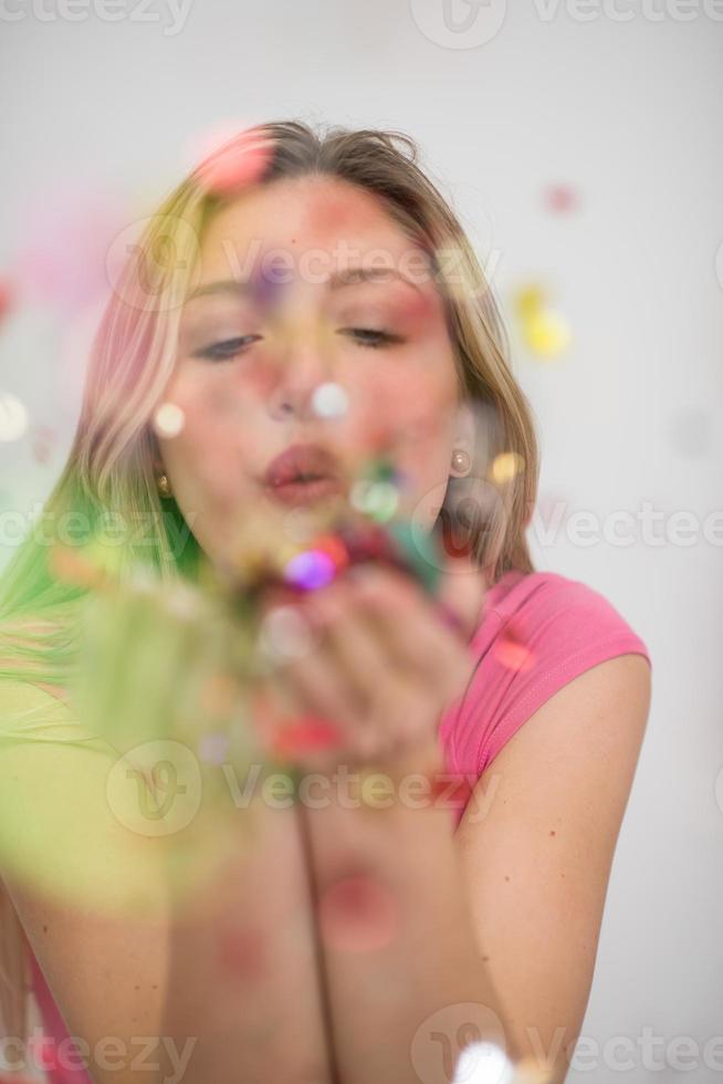 mujer soplando confeti en el aire foto