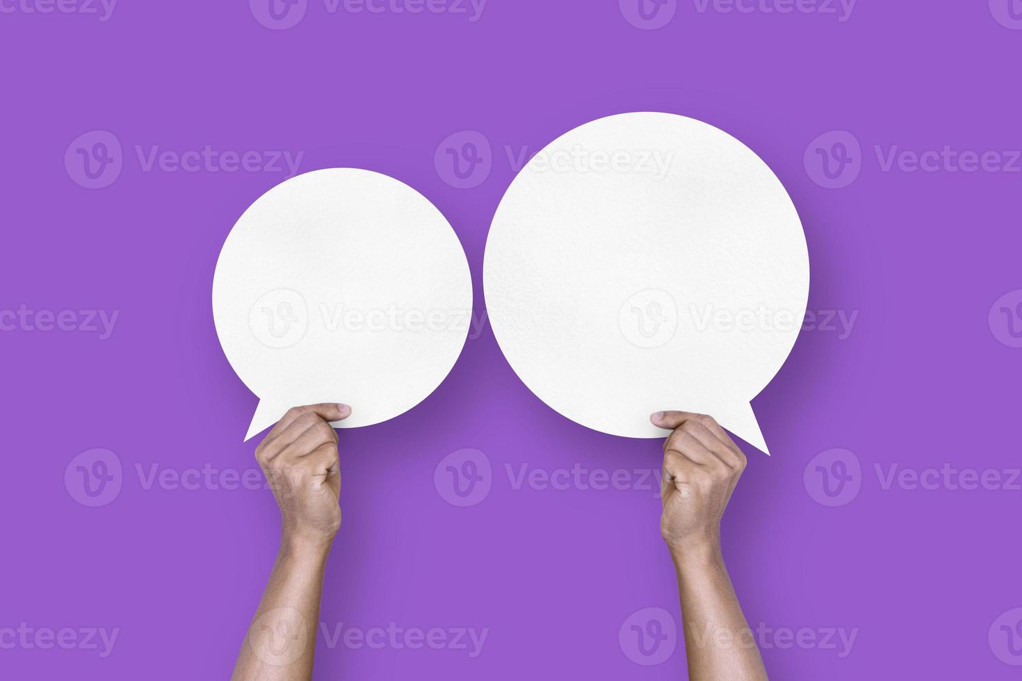 hand holding round white paper balloons speech bubbles isolated on purple background photo