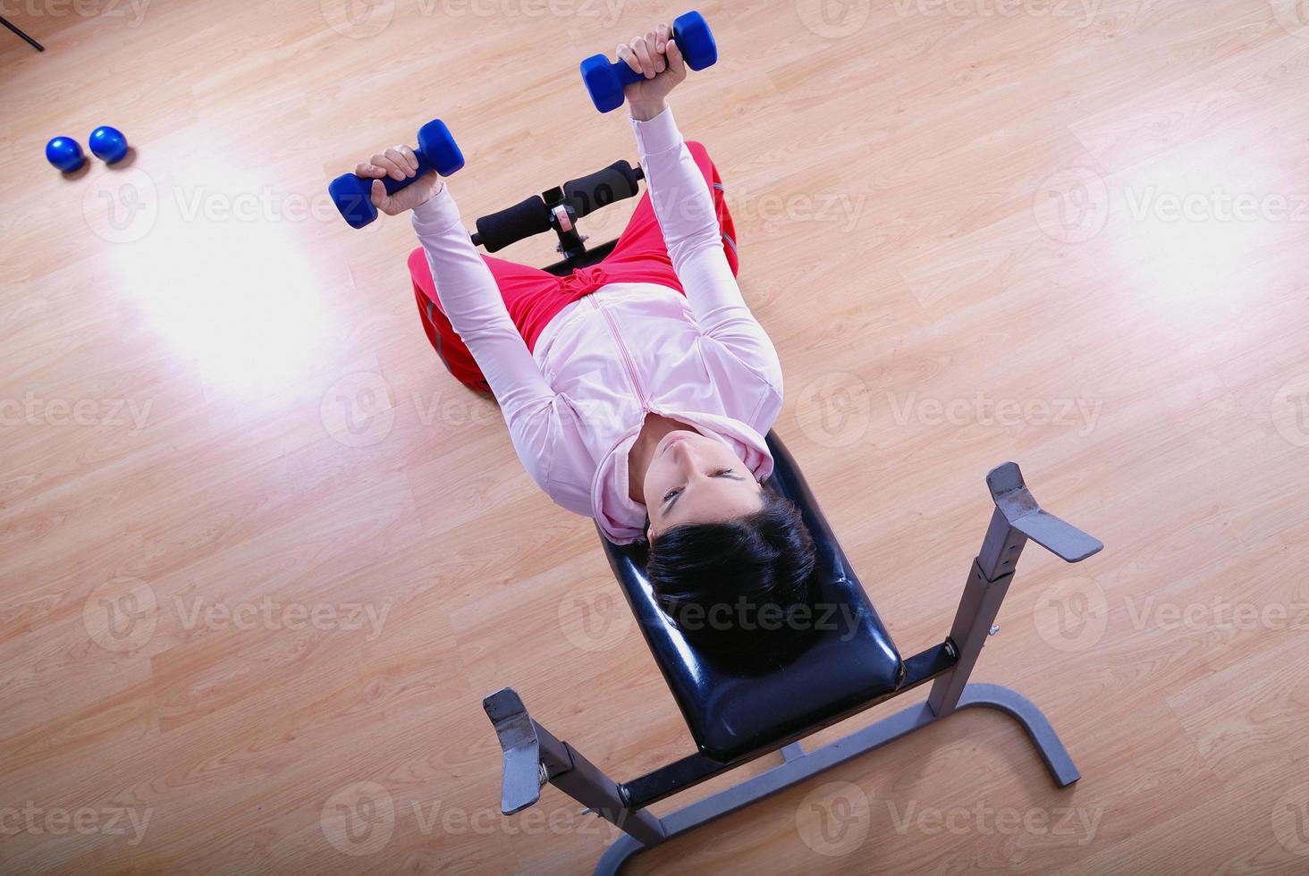 .a young woman weightlifting at gym photo