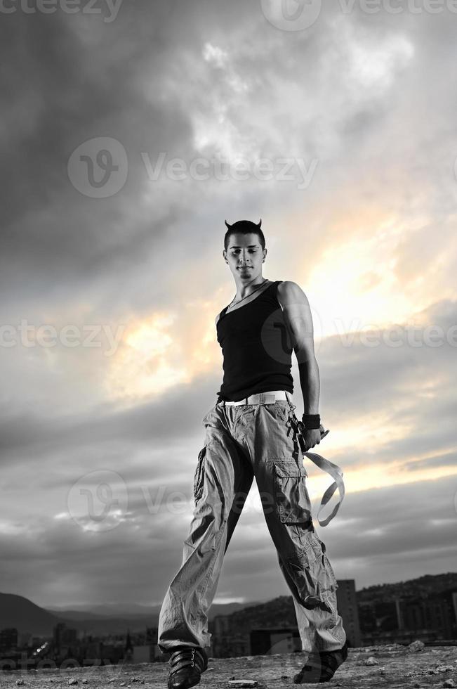 young man dancing and jumping  on top of the building photo