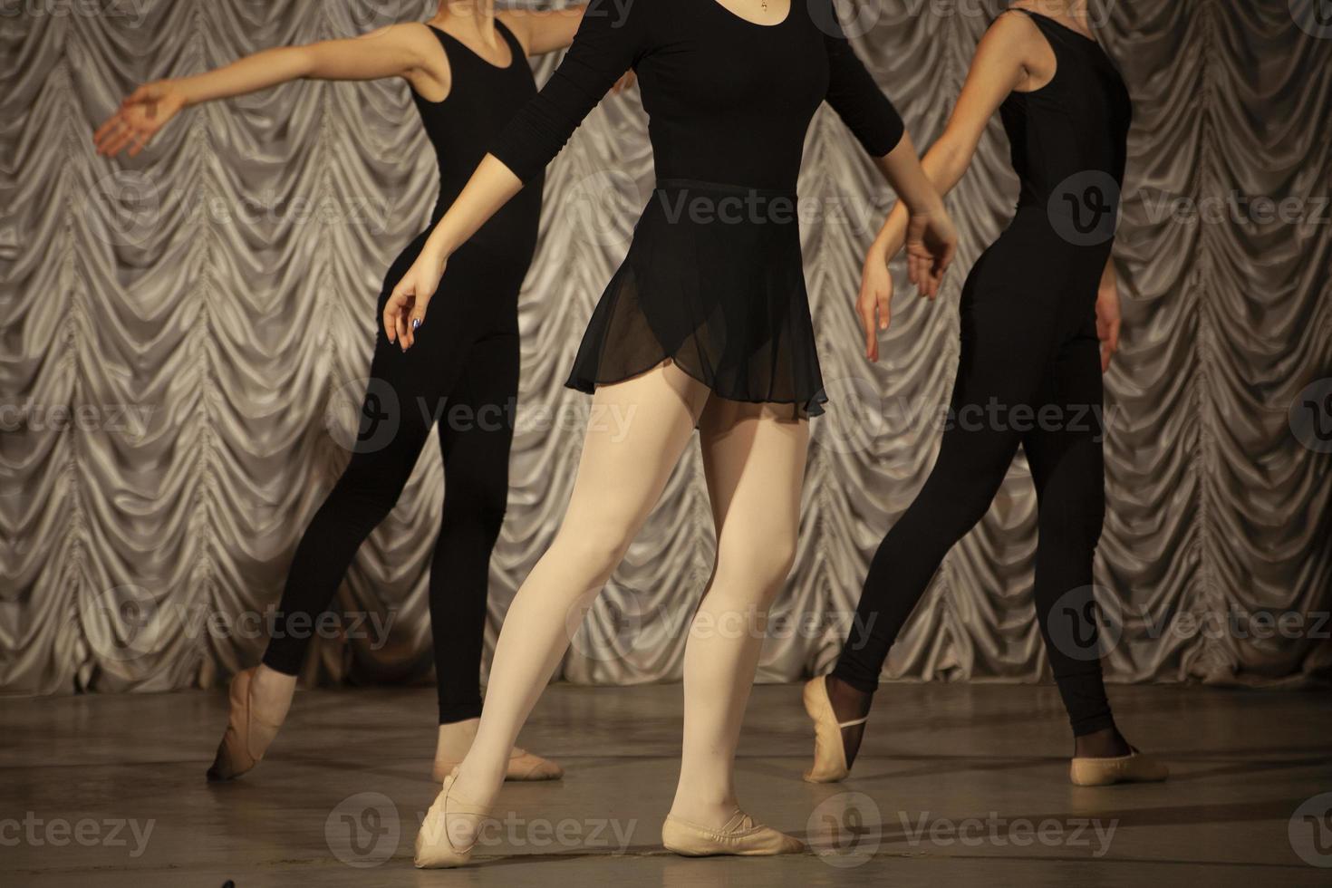 The girls rehearse the dance. Ballerinas in class. A girl in a black dress. photo