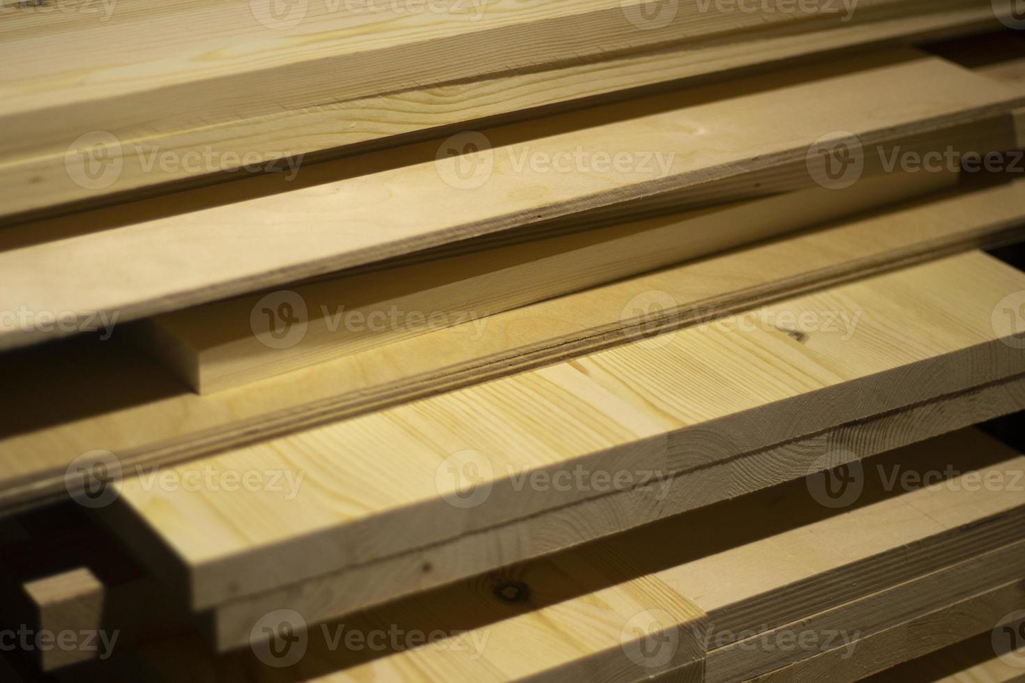 Boards in the carpentry workshop. The tree lies in a pile. photo