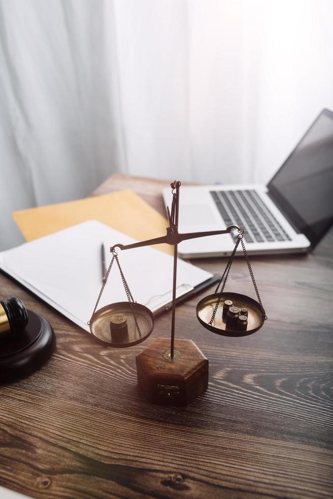 Business and lawyers discussing contract papers with brass scale on desk in office. Law, legal services, advice, justice and law concept picture with film grain effect photo