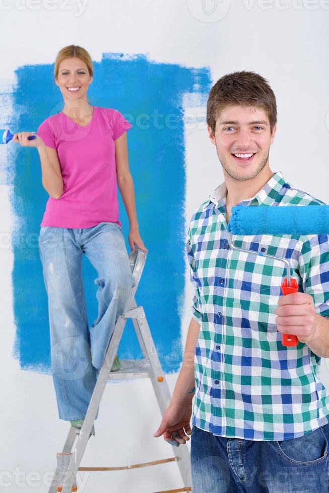 happy couple paint wall at new home photo