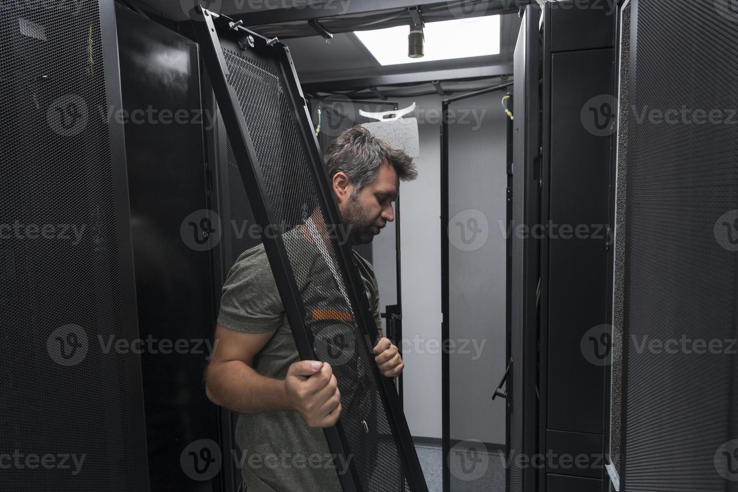 IT engineer working In the server room or data center The technician puts in a rack a new server of corporate business mainframe supercomputer or cryptocurrency mining farm. photo