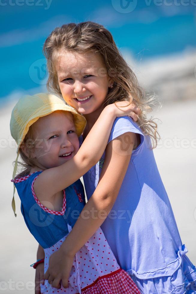 little sisters hugging on the beach coast photo
