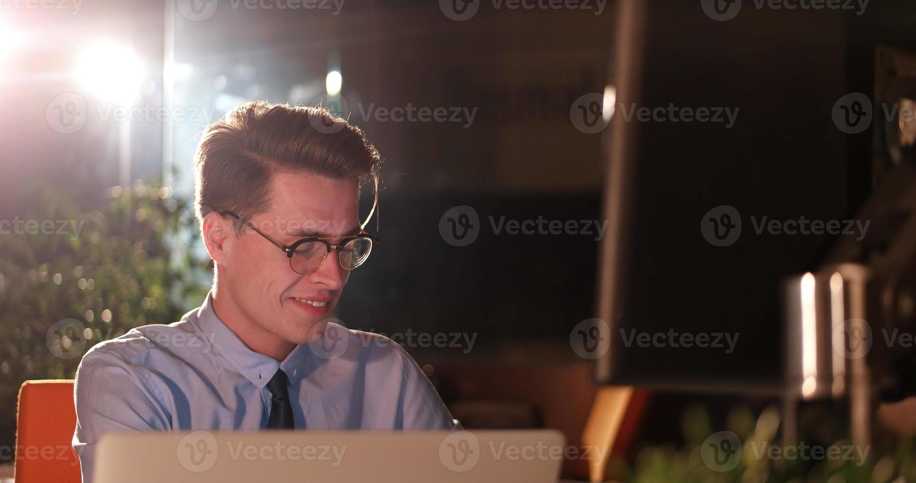 man working on computer in dark office photo