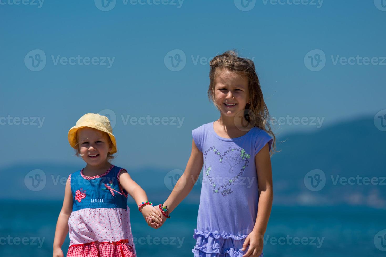 little sisters walking on the beach coast photo