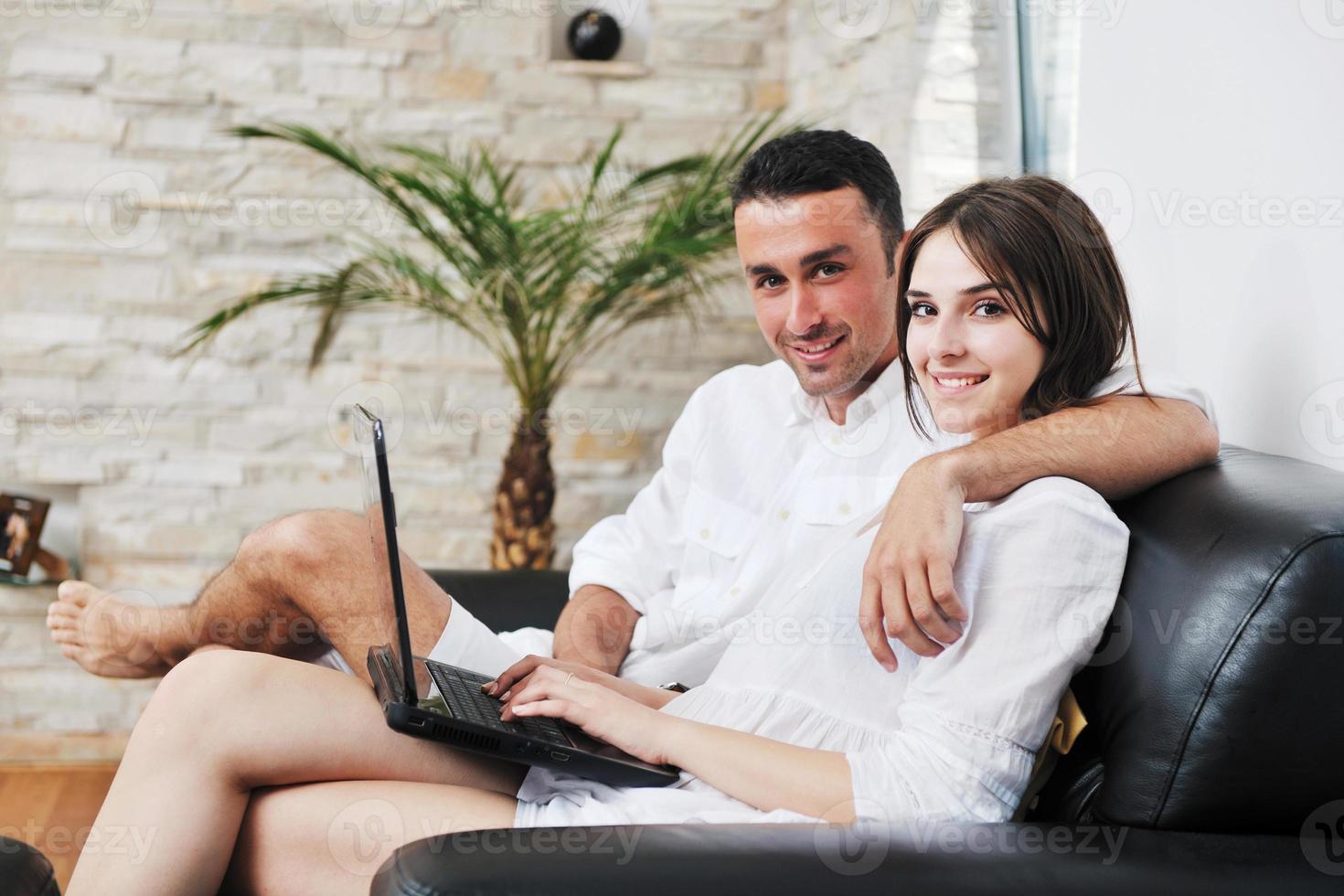 joyful couple relax and work on laptop computer at modern home photo