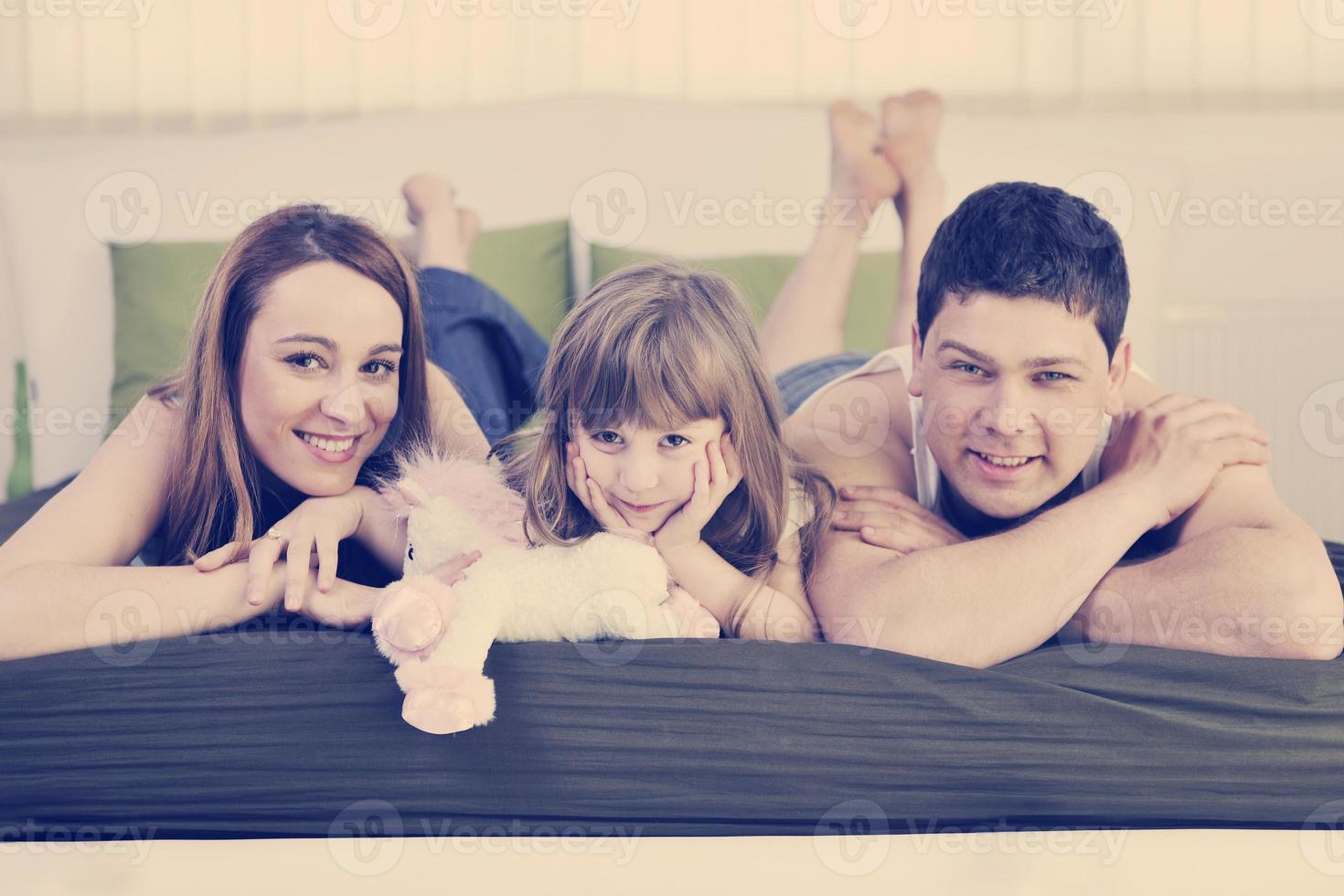 familia feliz descansando en la cama foto