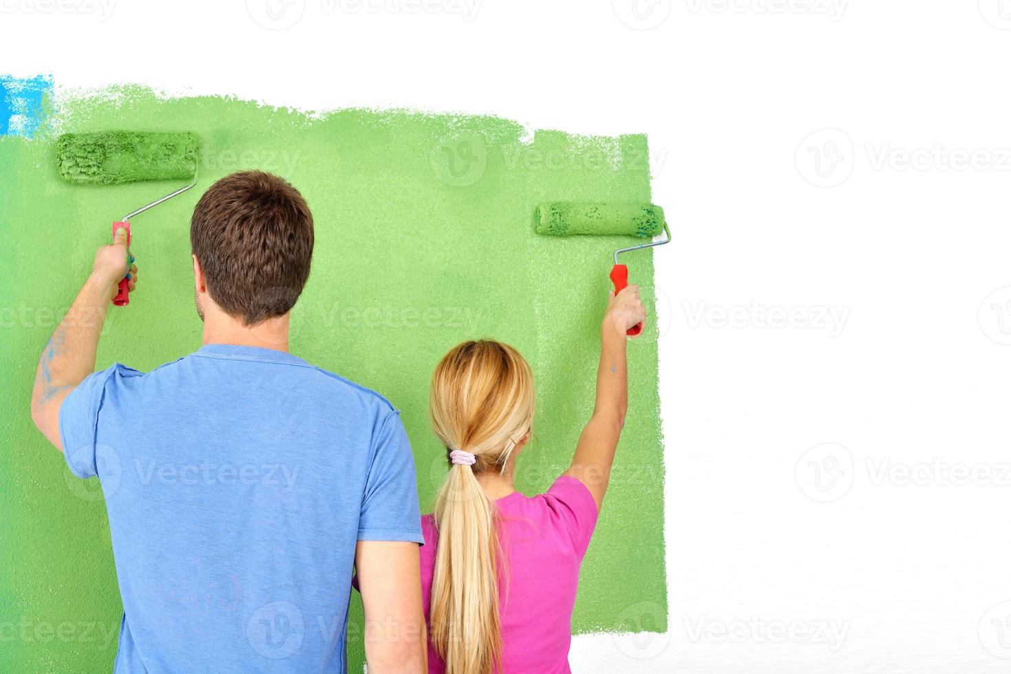 happy couple paint wall at new home photo