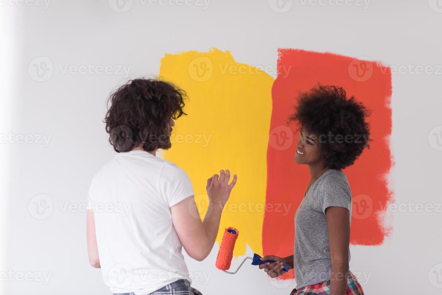 multiethnic couple painting interior wall photo