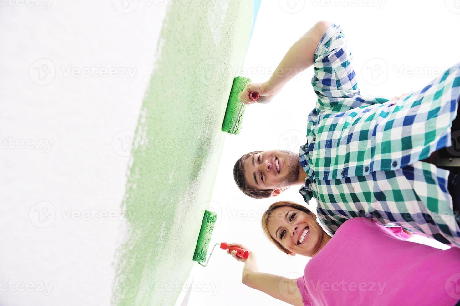 happy couple paint wall at new home photo