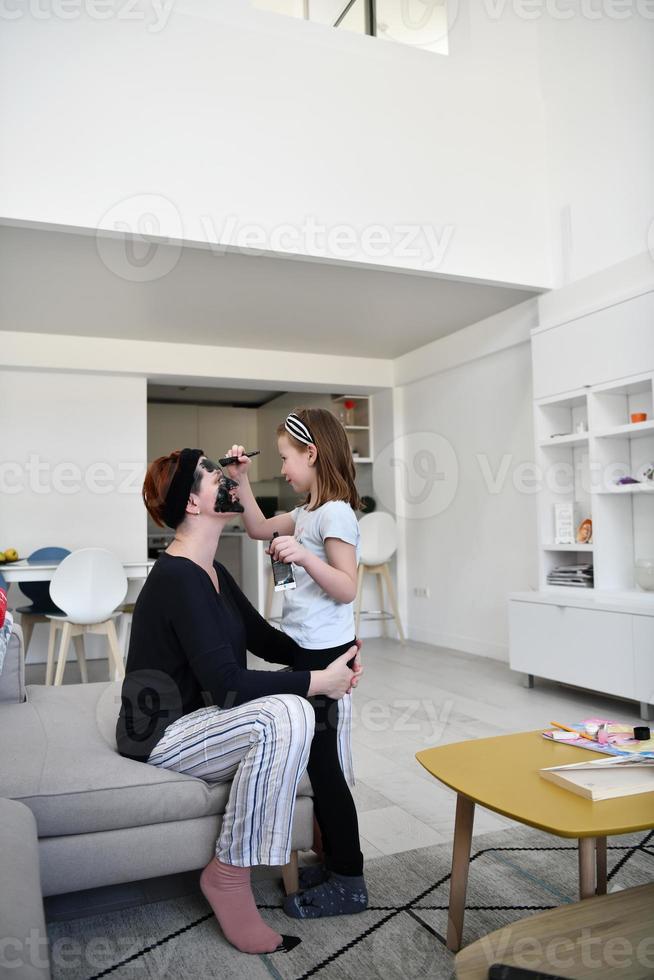 mother and daughter at home making facial mask beauty treatment photo