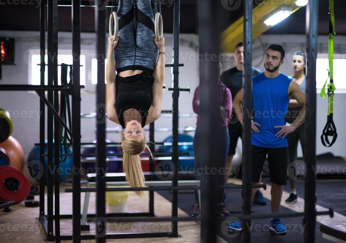 mujer trabajando con entrenador personal en anillos de gimnasia foto